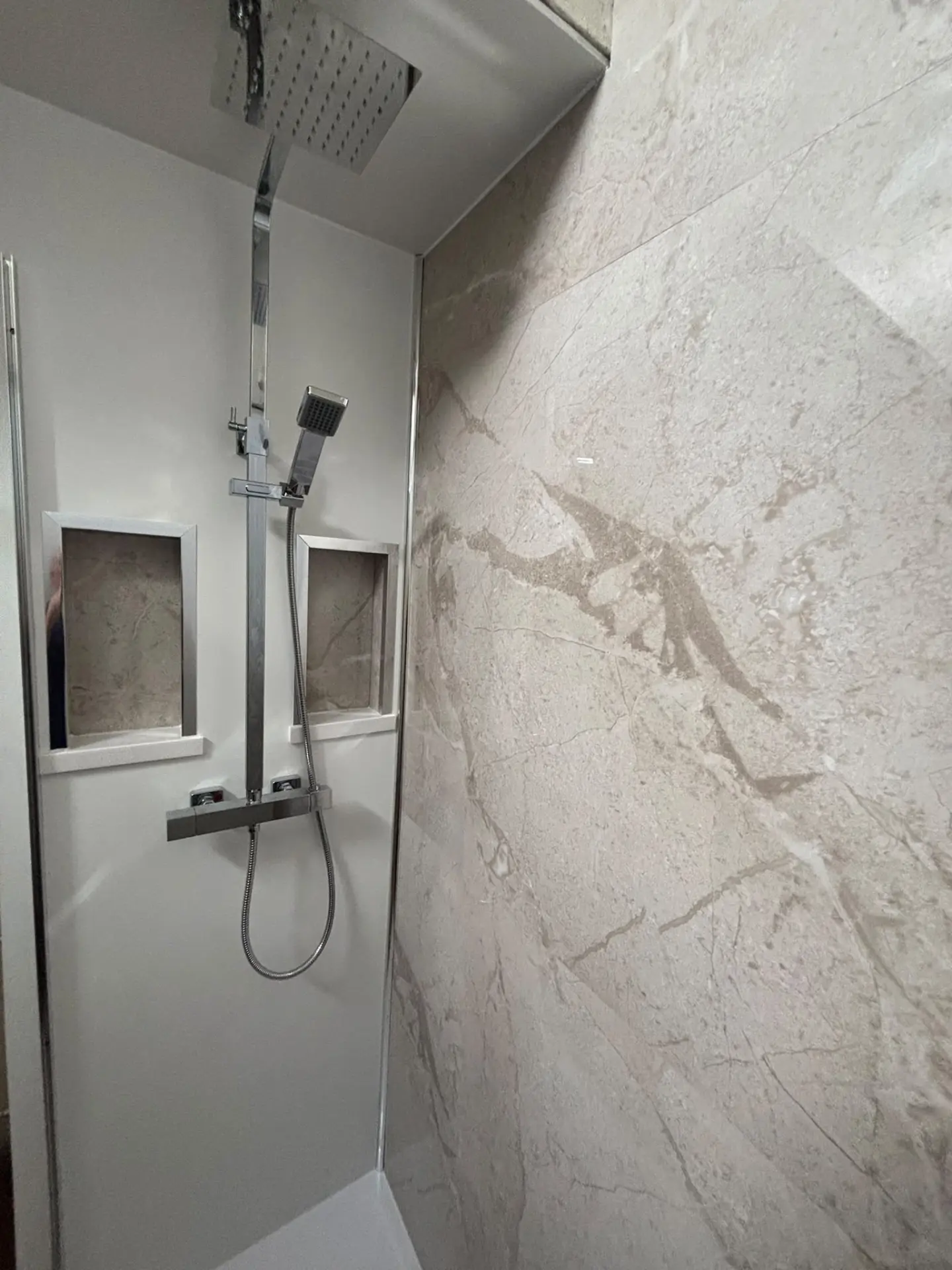 Shower with rainfall head, recessed niches and marble-effect wall boards