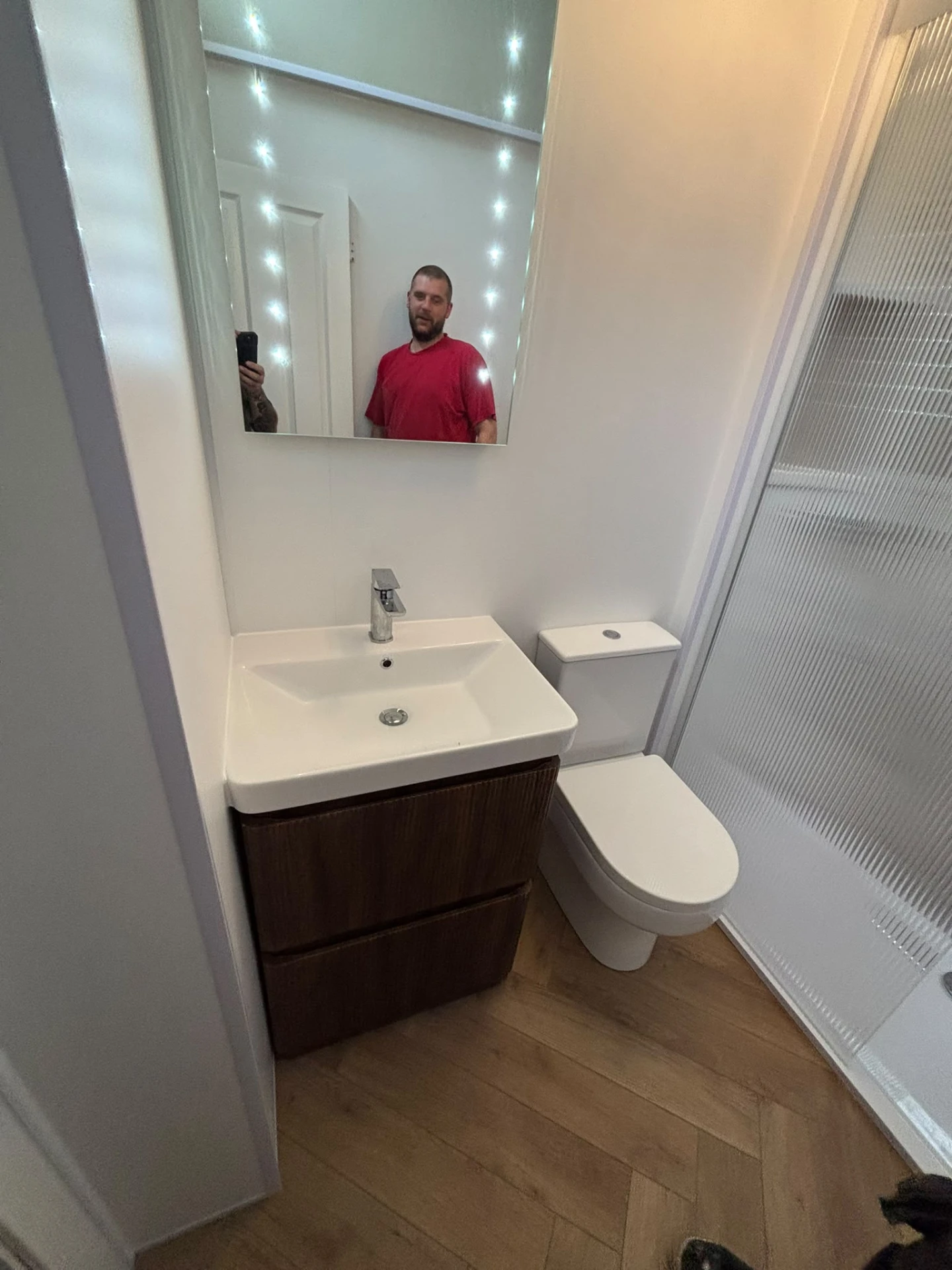 Walnut vanity unit with basin, close-coupled toilet and fluted glass shower screen
