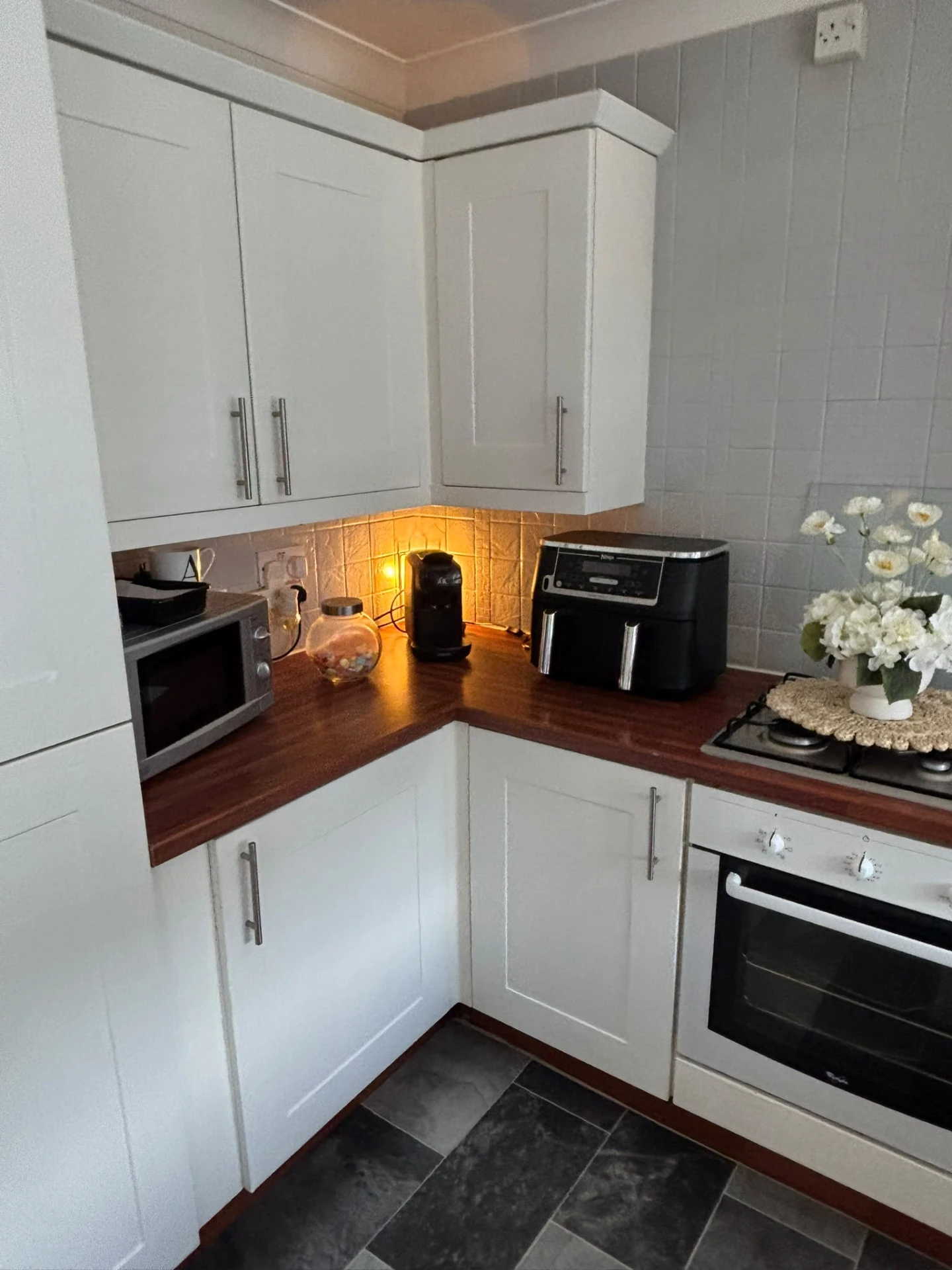 White shaker kitchen with wood worktops and under-cabinet lighting