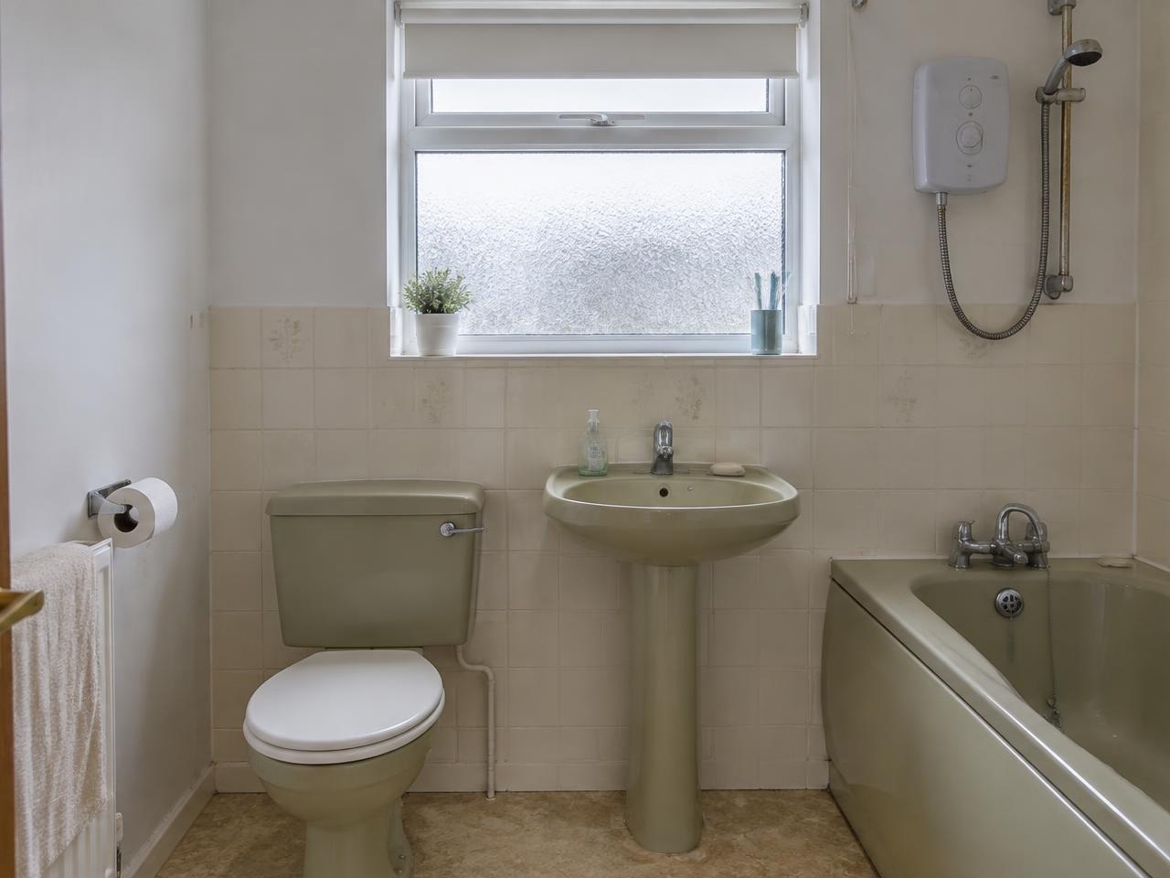 Bathroom with dated avocado suite before renovation